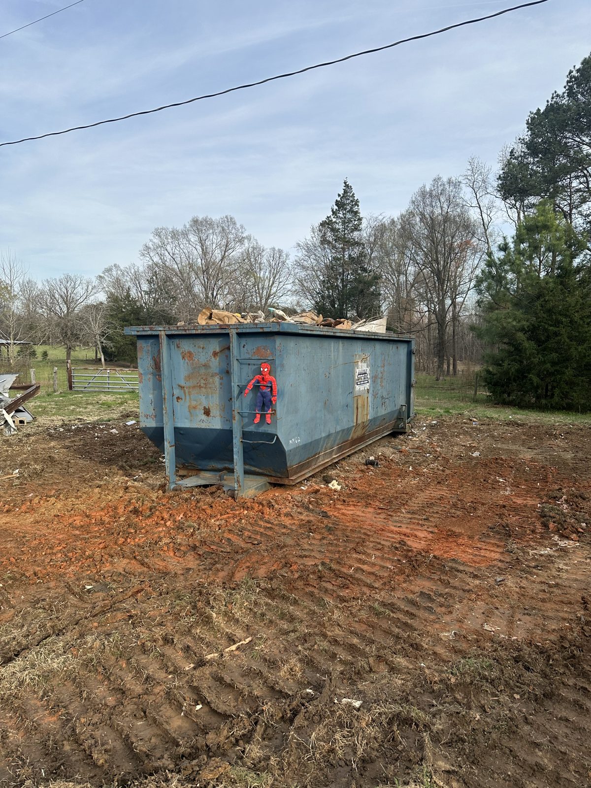 Cleared lot with loaded dumpster after demolition