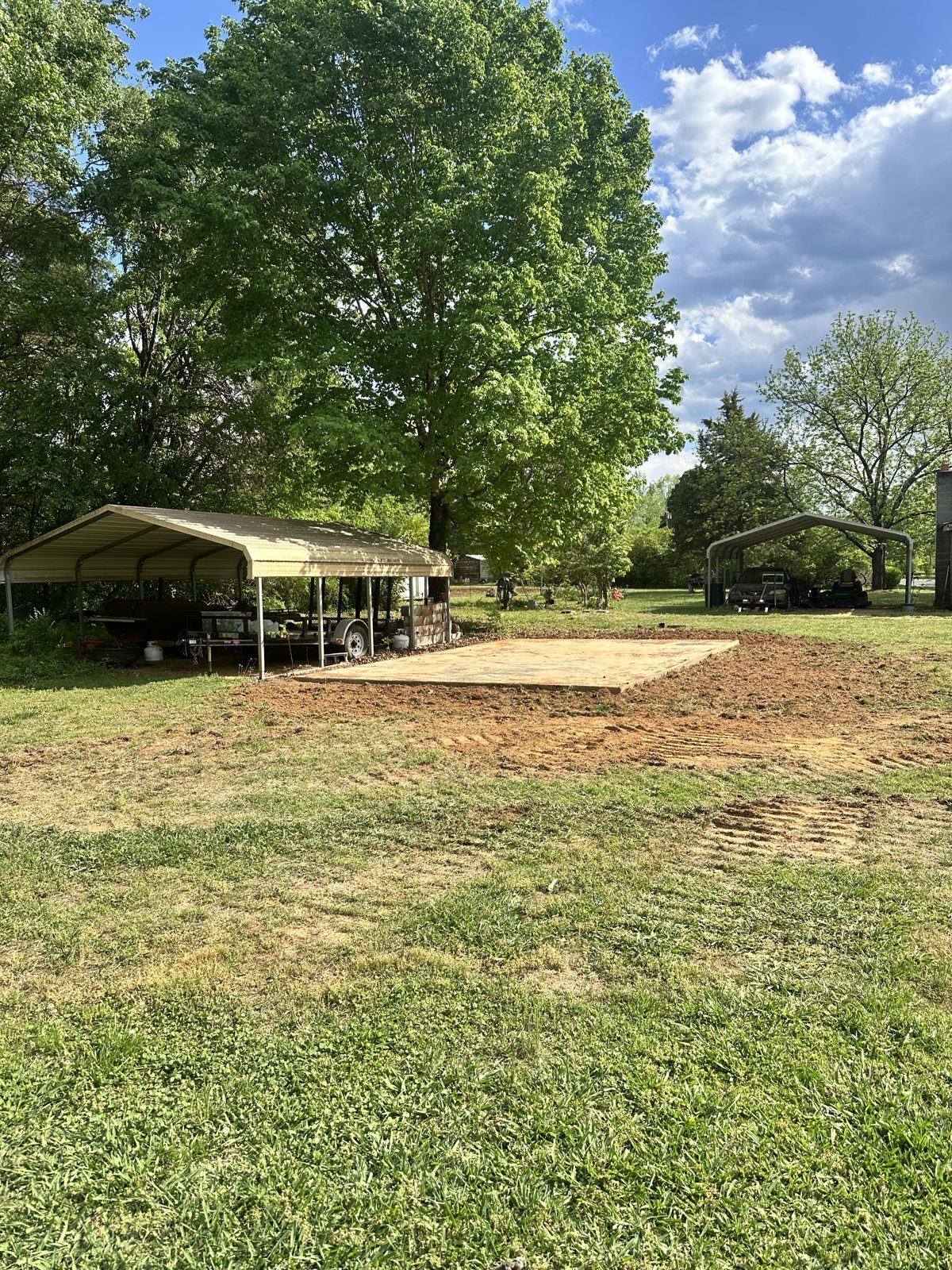 Cleared lot with concrete slab after shed demolition