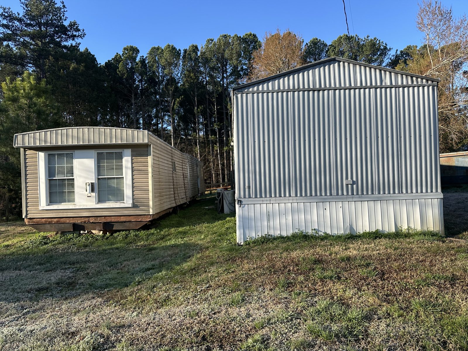 Mobile home and metal building before demolition